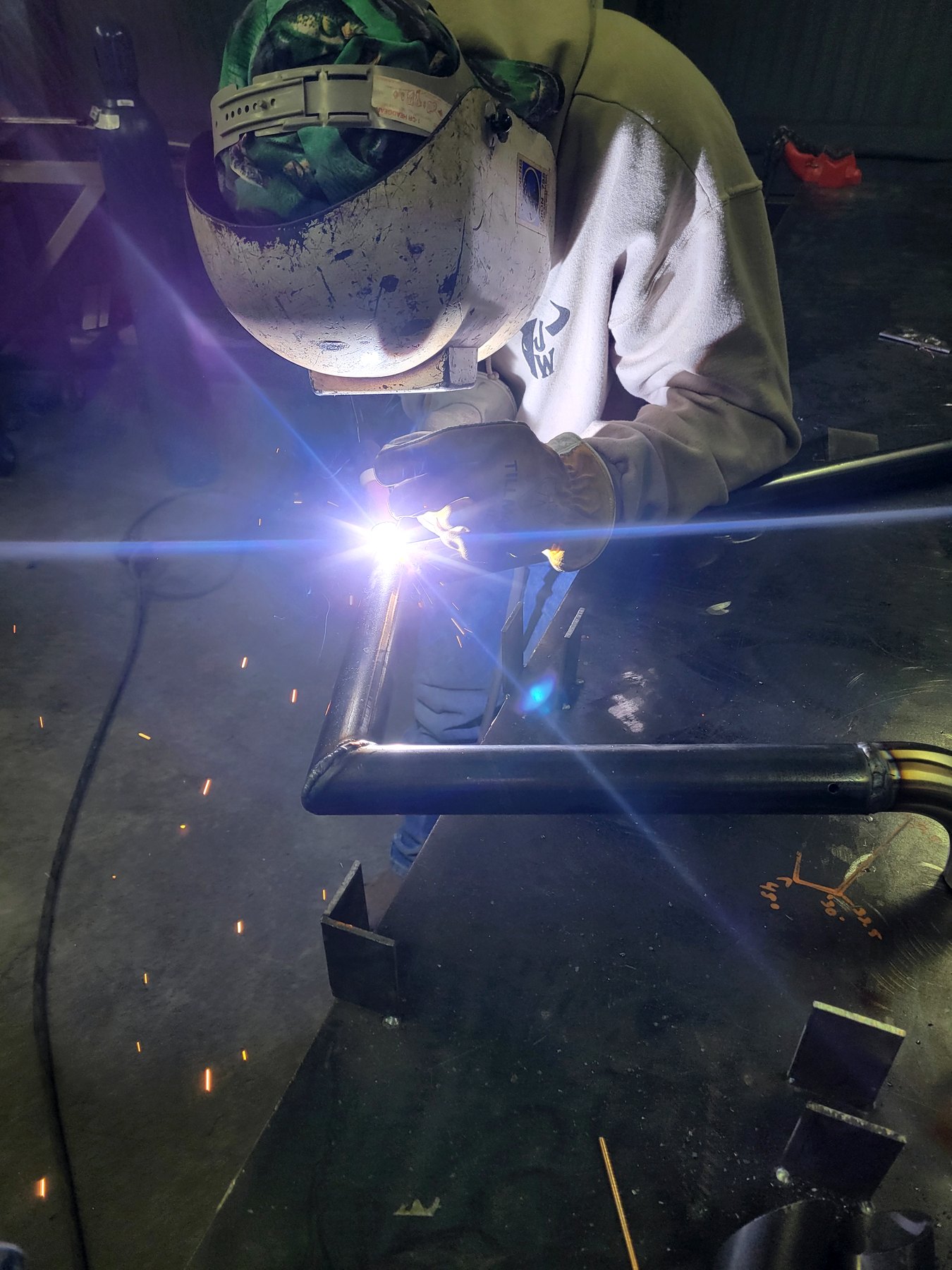 Close-up welding work on a steel component in a fabrication setting