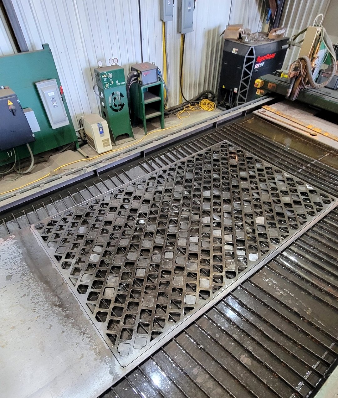 Steel fabrication table with cut metal parts in a fabrication shop