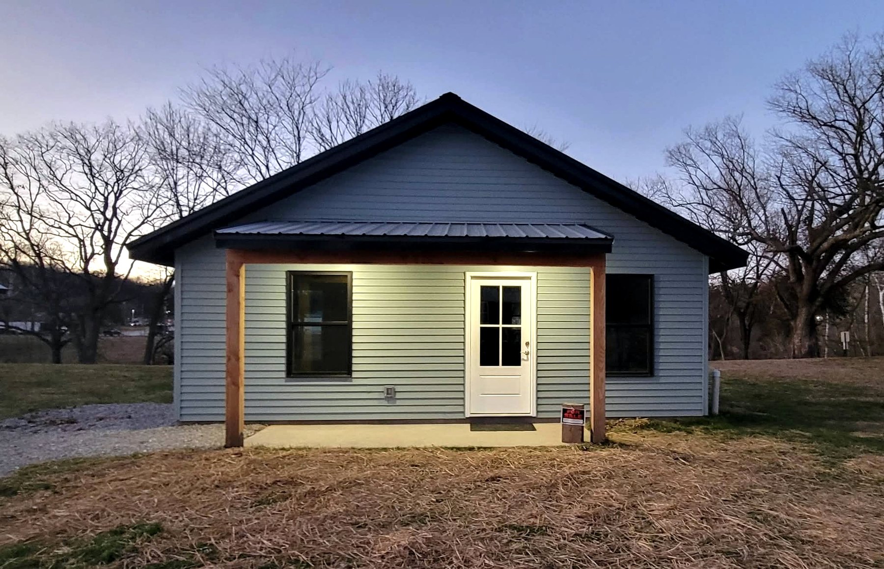 Finished small residential building with covered porch and metal roof
