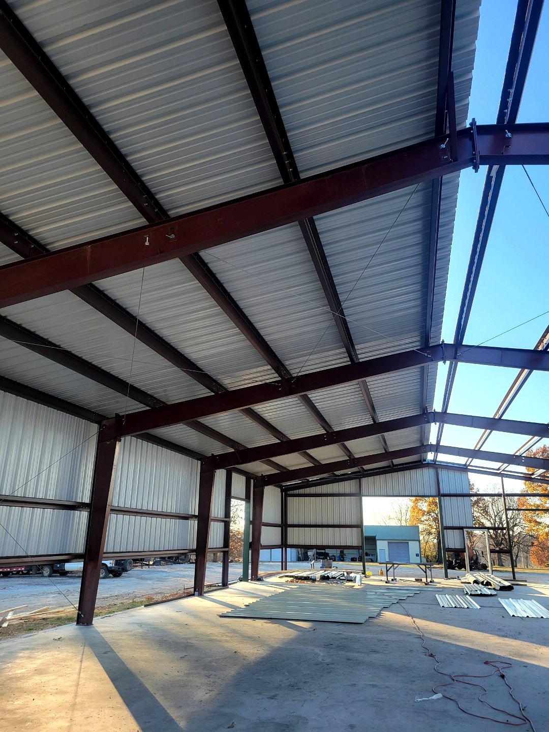 Interior bay of a commercial metal building with red iron frame and wall panels
