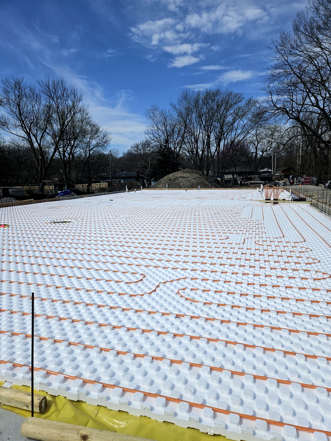 Foundation slab preparation with tubing laid out before concrete placement