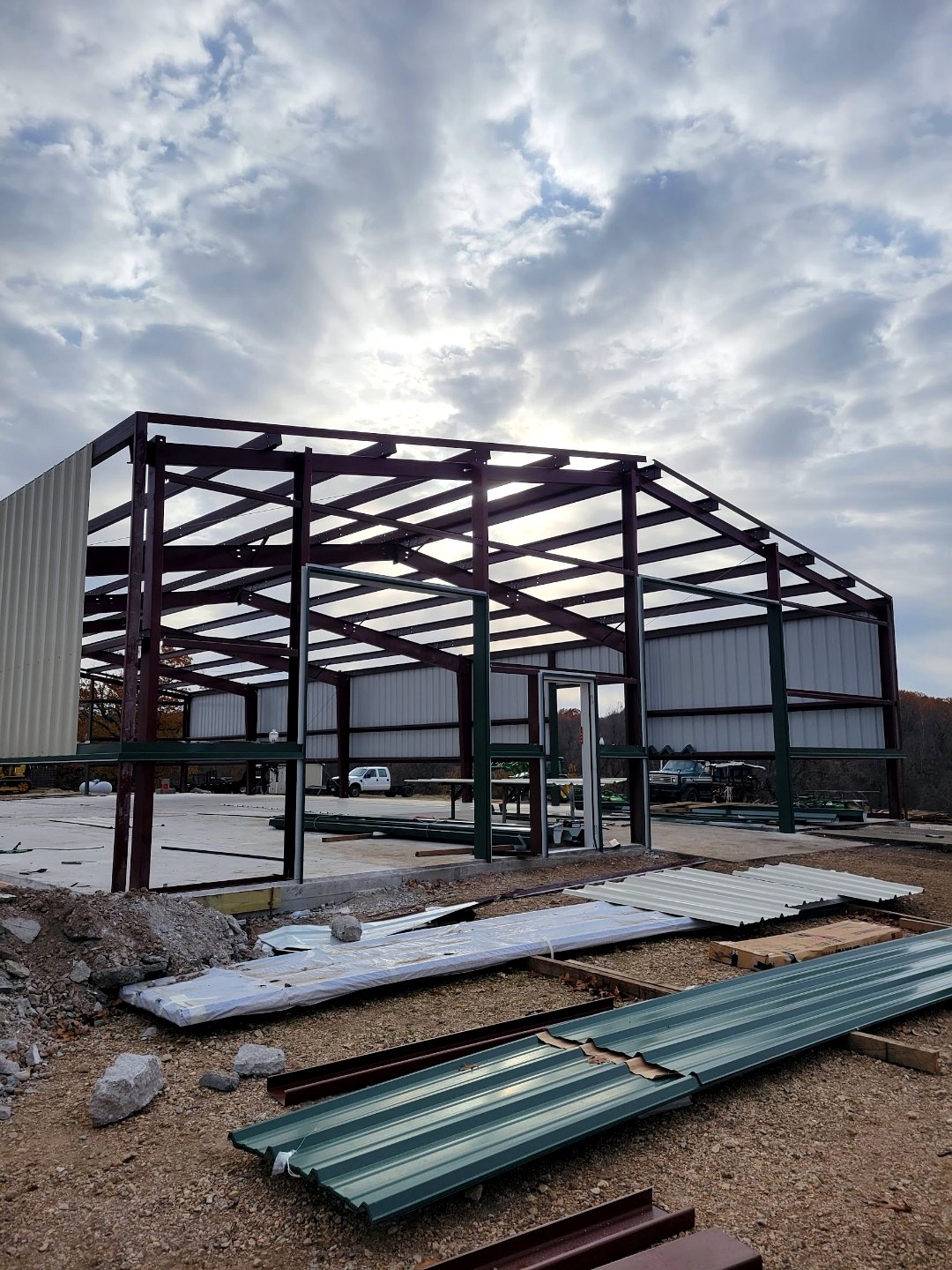 Commercial steel building frame under construction with red iron columns and rafters