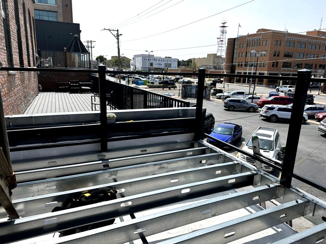 Steel deck framing installed beside a brick building in an urban setting